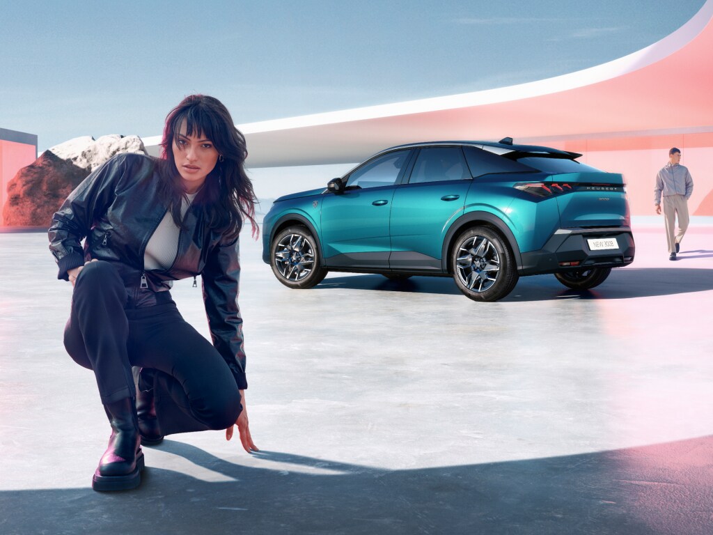 Woman kneeling next to new PEUGEOT 3008 hybrid with rear view